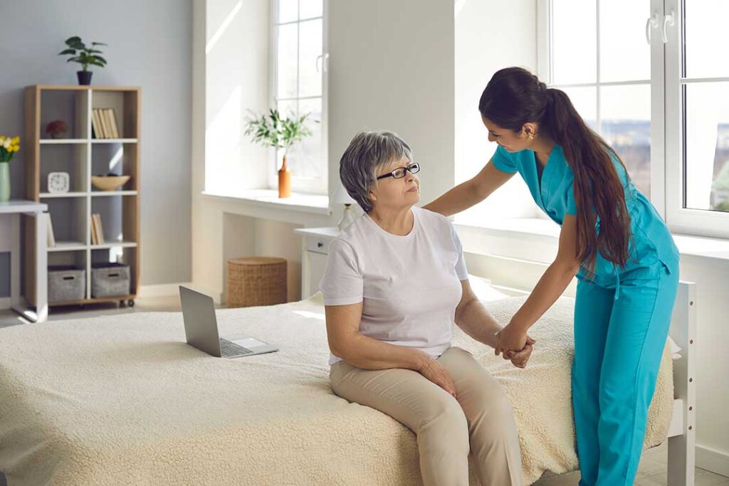 Older adult arranging familiar belongings in a bright assisted living room with family nearby