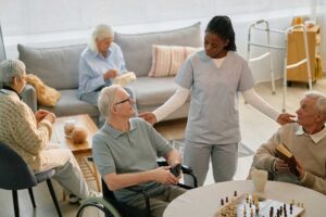 Older resident and caregiver discuss a meal plan beside a small prayer book in a bright assisted living room.