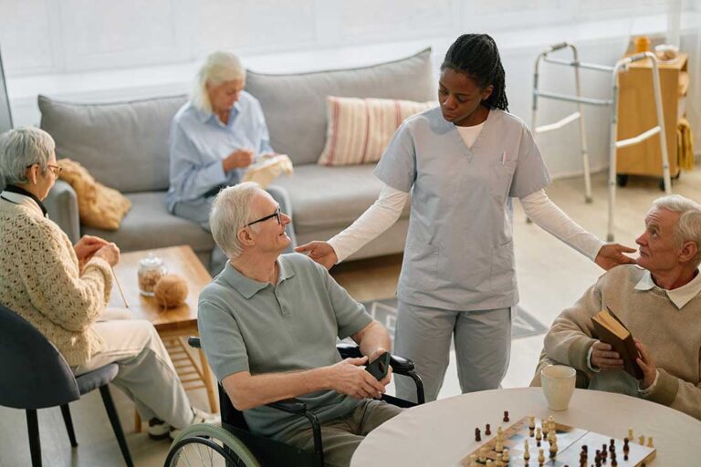 Older resident and caregiver discuss a meal plan beside a small prayer book in a bright assisted living room.